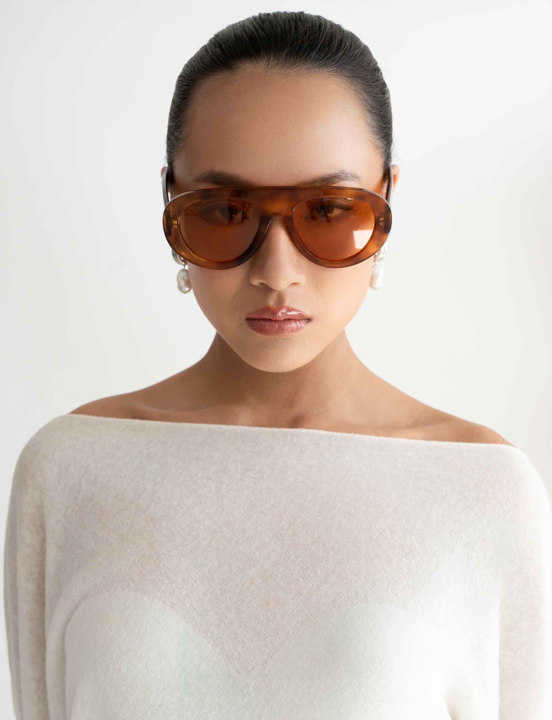 The Muse Orange Tortoise sunglasses worn, front view